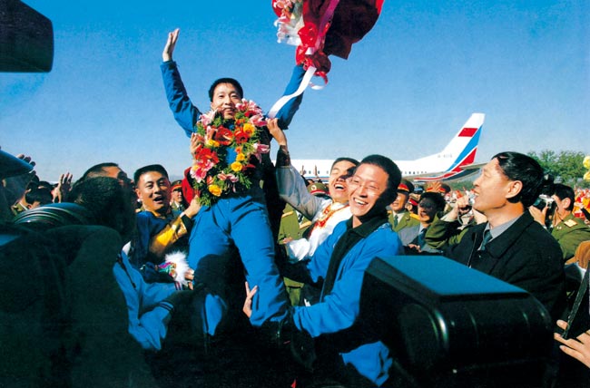 2003年10月16日 執行神舟五號任務(wù)航天員楊利偉返回西郊機場(chǎng)被歡呼的人群拋起 攝影：朱九通